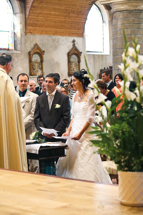 plantes en premier plan floues bokeh et mariés nets en arrière plan photo vintage de mariage