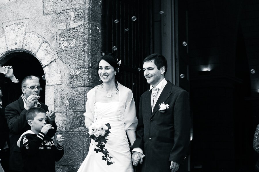 Portrait large en noir et blanc fort contraste, couple sortie d'église sous les cotillons Marseille