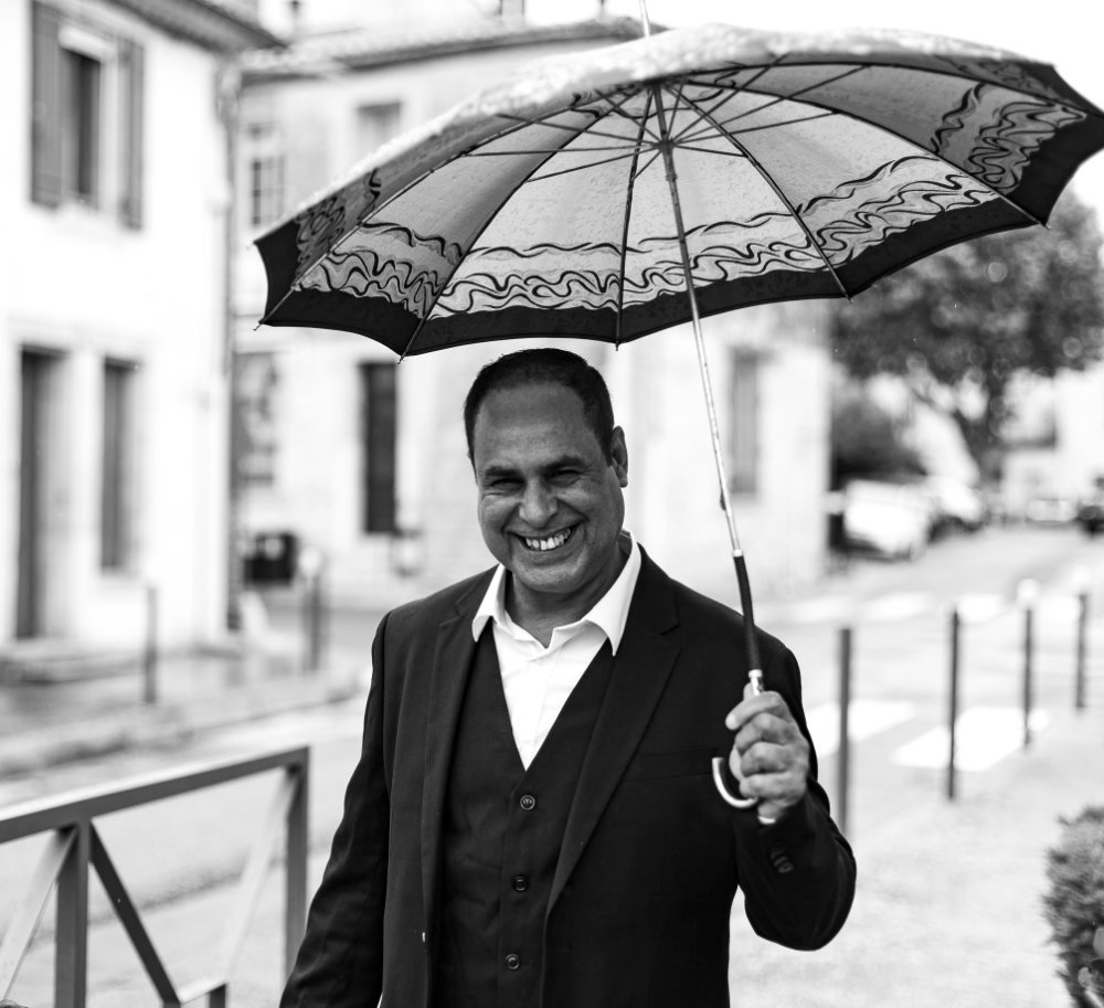 Un marié heureux sous la pluie avec son parapluie dans le sud de la France photo en N&B au style vintage